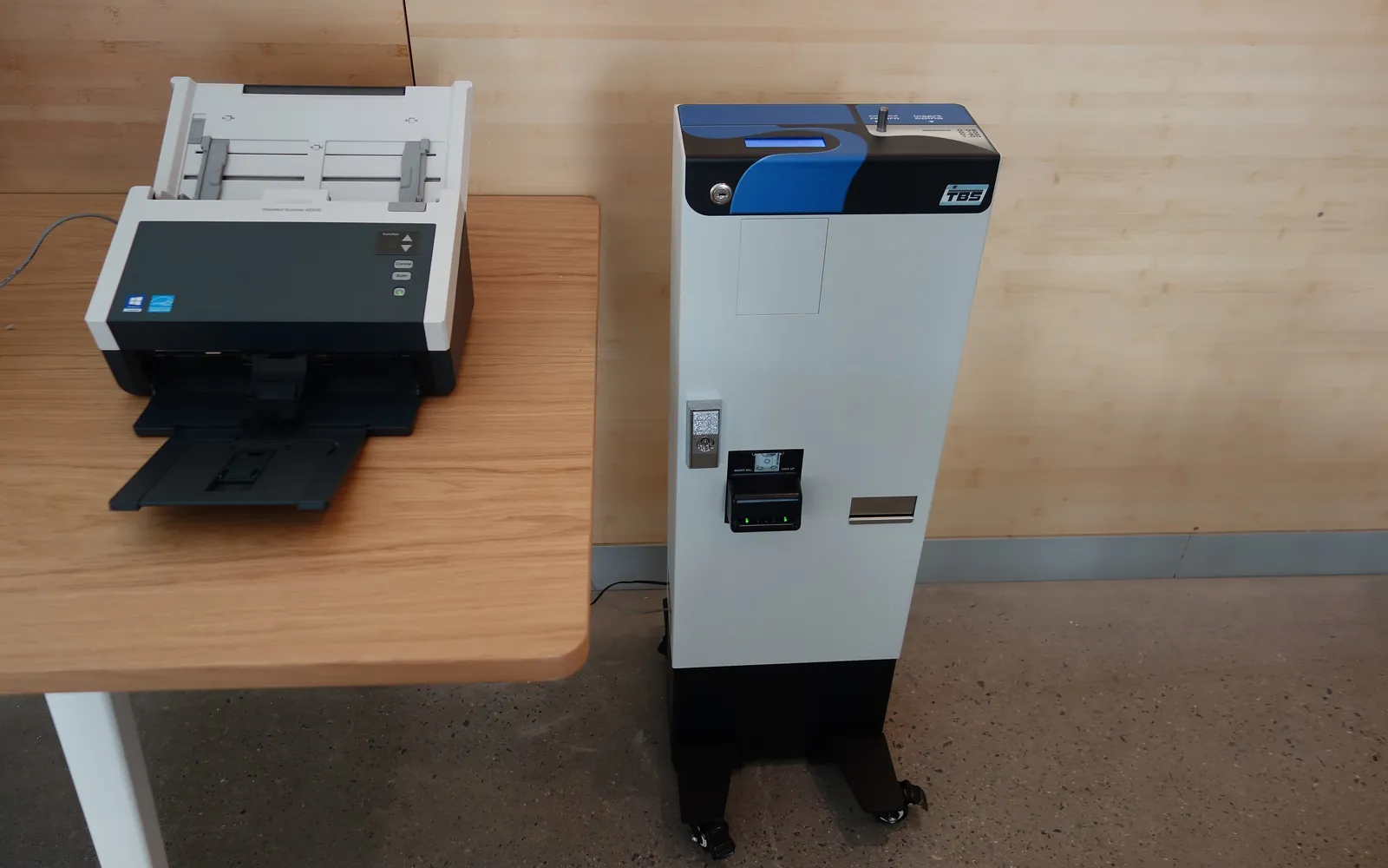 A print release terminal next to an office printer